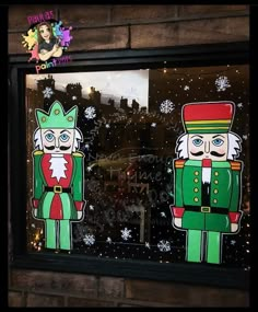 two nutcrackers in green and red are painted on the glass windows of a store