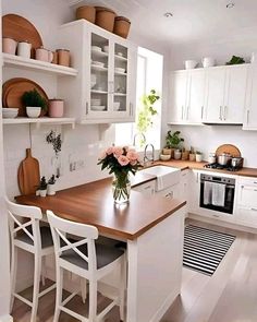 a kitchen with white cabinets and wooden counter tops