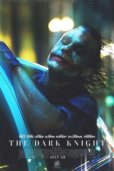 the dark knight movie poster with joker looking down at his arm and head, in front of