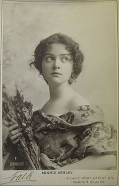 an old black and white photo of a woman holding flowers