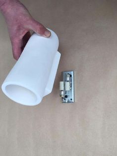 a hand is holding a white plastic object