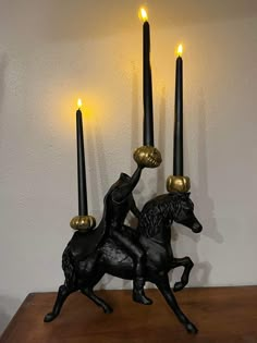 a statue of a horse and rider holding two candles