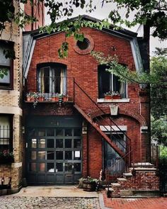 an old brick building with stairs leading up to the second story and windows above it