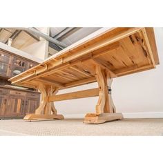 a large wooden table sitting on top of a carpeted floor next to a dresser