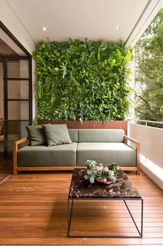 a living room with a couch and coffee table in front of a large green wall