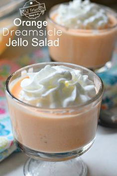 two glasses filled with orange jello and whipped cream