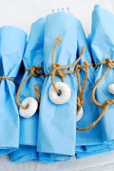 blue napkins tied up with rope and white doughnuts on each one side