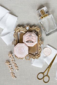 wedding rings, ring box, and other accessories laid out on top of the table