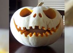 a carved pumpkin with an evil face on it's side, sitting on a table