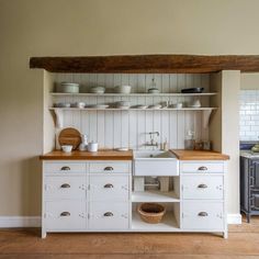 an old fashioned kitchen with white cabinets and wood counter tops, is pictured in this image