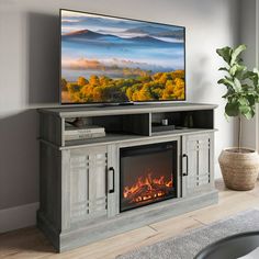 a flat screen tv sitting on top of a wooden entertainment center next to a fire place