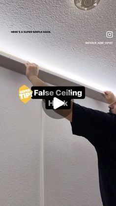 a man is fixing the ceiling in his room with an electric light fixture on it