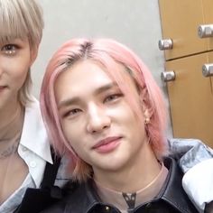 two young men with pink hair are posing for the camera