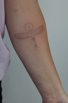 a woman's arm with a small bird tattoo on the left side of her arm