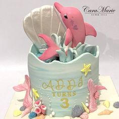 a birthday cake with a dolphin and seashells in it