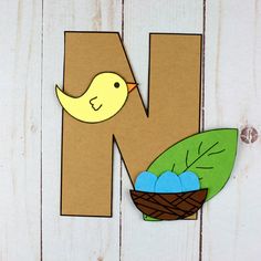 the letter n is made out of cardboard and has a bird sitting on top of it