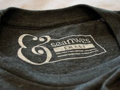 a black t - shirt with the logo and seal on it