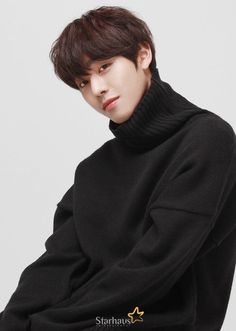 a young man sitting on top of a chair wearing a black turtle neck sweater