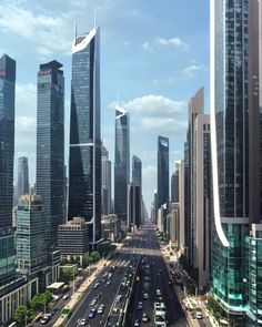 an aerial view of a city with tall buildings and cars driving down the street in front of them