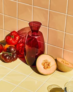 a table topped with lots of different types of fruits and vegetables next to a vase filled with water