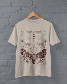 Moths and Mushrooms T-shirt Printed on a super soft, cotton tee Dispatched in 5 working days or sooner Unisex Free UK delivery Material: 100% ringspun cotton. Chest (to fit): S  34/36   M  38   L  40/42   XL  44/46   XXL  48/50 ECO-FRIENDLY Each garment is made to order, reducing extra material and energy that would be otherwise wasted We use DTG printing process which is easier on the environment than screen-printing Our ink is bright and also eco-friendly. Do not tumble dry Wash at 30 degrees Fairy Grunge Crew Neck T-shirt With Screen Print, Fairy Grunge Crew Neck T-shirt Relaxed Fit, Fairy Grunge Relaxed Fit Crew Neck T-shirt, Fairycore Graphic Print Short Sleeve T-shirt, Cotton Fairycore T-shirt With Crew Neck, Cotton Fairycore Crew Neck T-shirt, Crew Neck Cotton T-shirt In Fairycore Style, Fairycore Cotton Crew Neck T-shirt, Cotton Crew Neck T-shirt In Fairycore Style