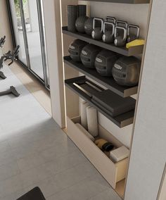 there are many gym equipment on the shelves in this room, including kettles and exercise balls