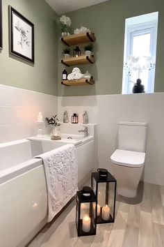 a white bathroom with two candles on the floor