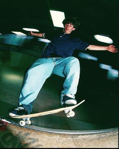 a young man riding a skateboard on top of a metal ramp in a dark room