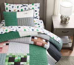 a bed with green, white and pink quilted bedspreads