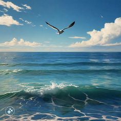 a seagull flying over the ocean waves under a blue sky with white clouds