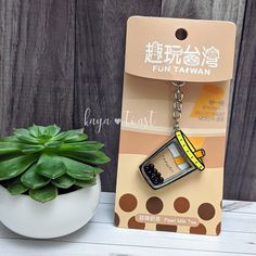 a keychain shaped like a bus is sitting next to a potted plant