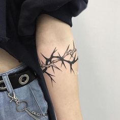 a black and white photo of a tattoo on the left arm with barbed wire around it