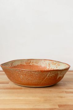 a brown bowl sitting on top of a wooden table