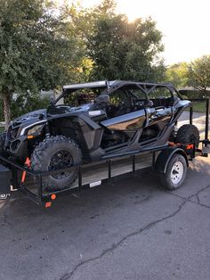 a black and silver atv pulling a trailer