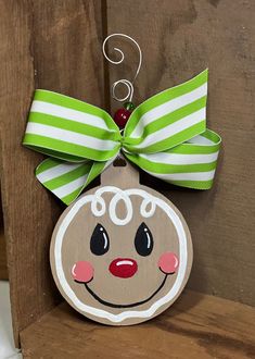 a wooden ornament with a green bow on it