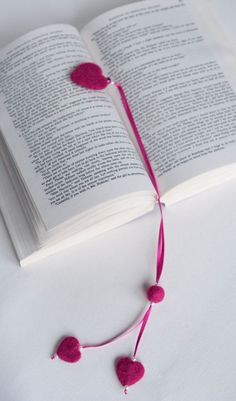 an open book with pom - poms attached to it