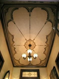 an ornate ceiling with chandeliers and lights in a building's entryway