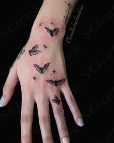 a woman's hand with bats on it and stars in the sky above her