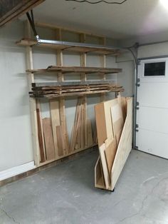 a garage filled with lots of wooden planks next to a white door and storage area