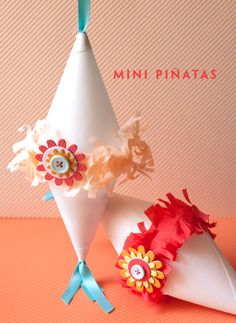 two white cones with flowers and buttons on them