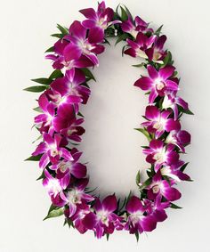 purple flowers arranged in the shape of a letter o on a white background with green leaves