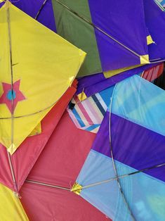 many different colored kites are stacked together