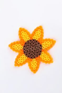 an orange and yellow flower made out of legos on a white background stock photo