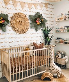 a baby's room with a giraffe statue in the corner and wall decorations