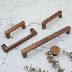 three wooden handles and knobs on a marble surface