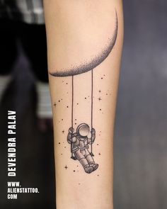 an astronaut floating in the sky on a string tattoo