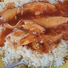 a yellow plate topped with rice and meat covered in gravy