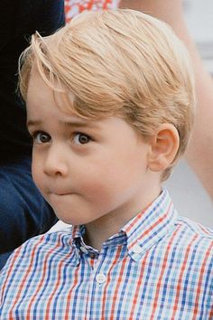 a young boy with blonde hair wearing a plaid shirt