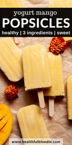 popsicles with mango and orange zest on top, surrounded by other fruit pieces