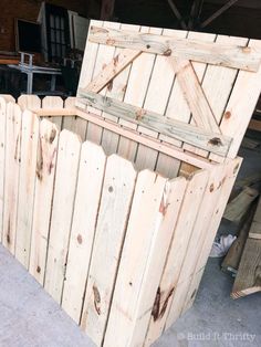 an old wooden box sitting on top of a cement floor next to a pile of pallets